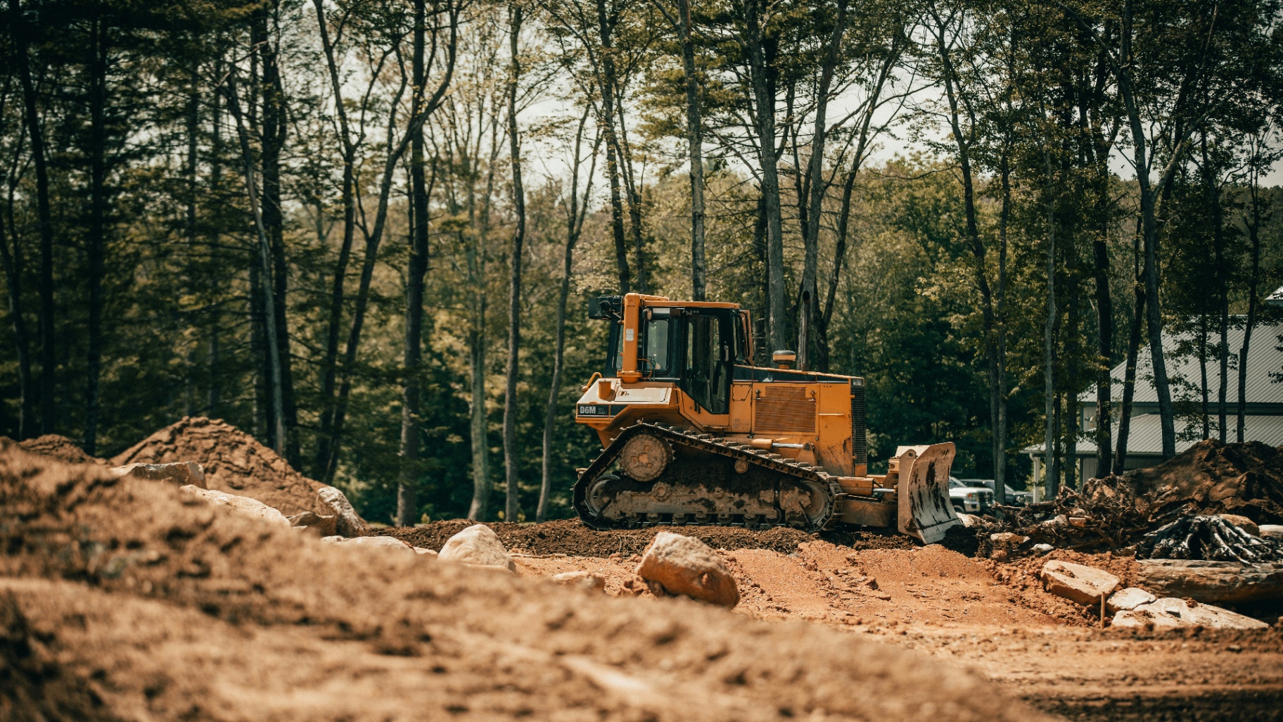 Excavator working on a septic system installation site on a forested Revelstoke property